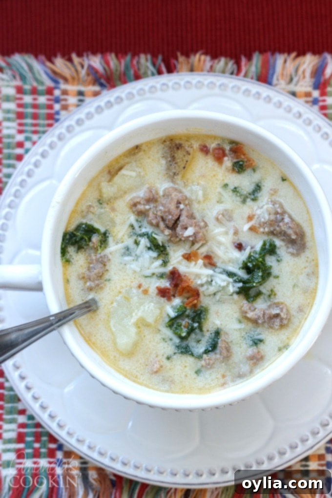 Bowl of Zuppa Toscana soup garnished with fresh Parmesan and bacon bits