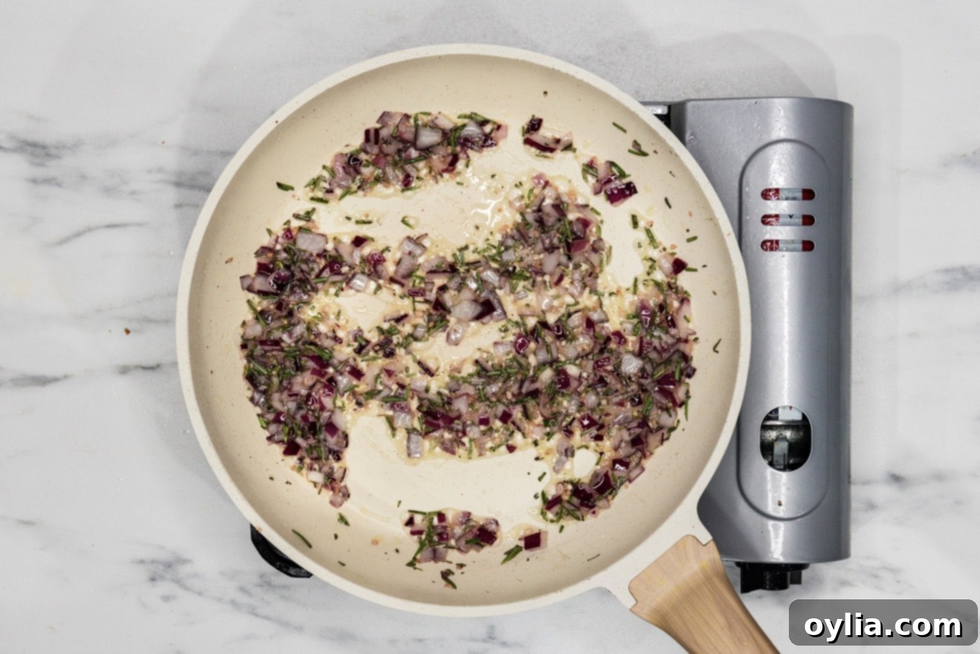 onion, garlic, and rosemary sauteeing in a skillet