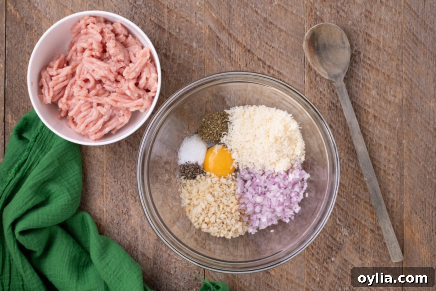 ground chicken in a bowl next to meatball ingredients
