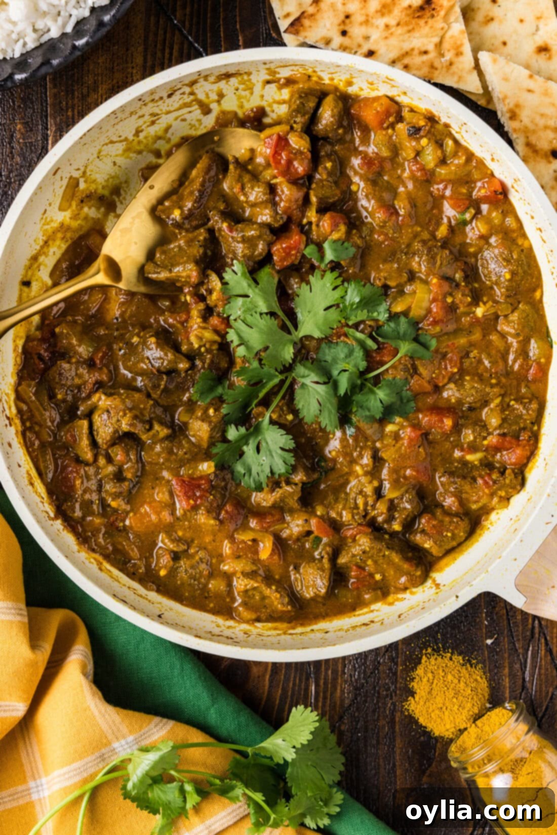 Skillet of Beef Curry with a spoon in it