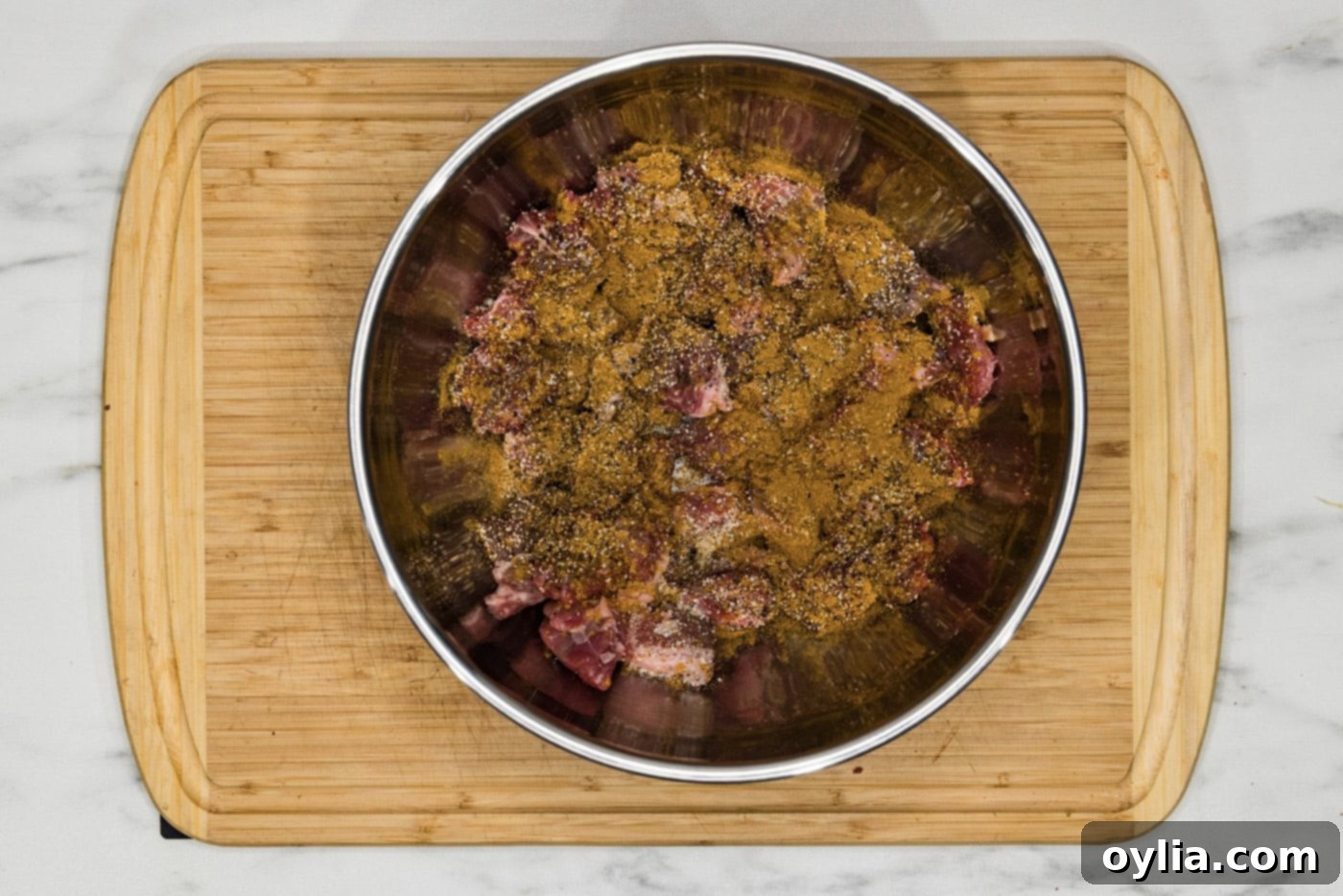 beef cubes in a bowl with seasonings