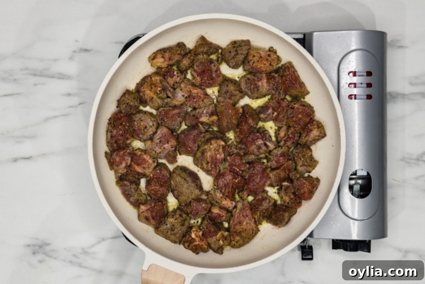 beef cubes cooking in a skillet