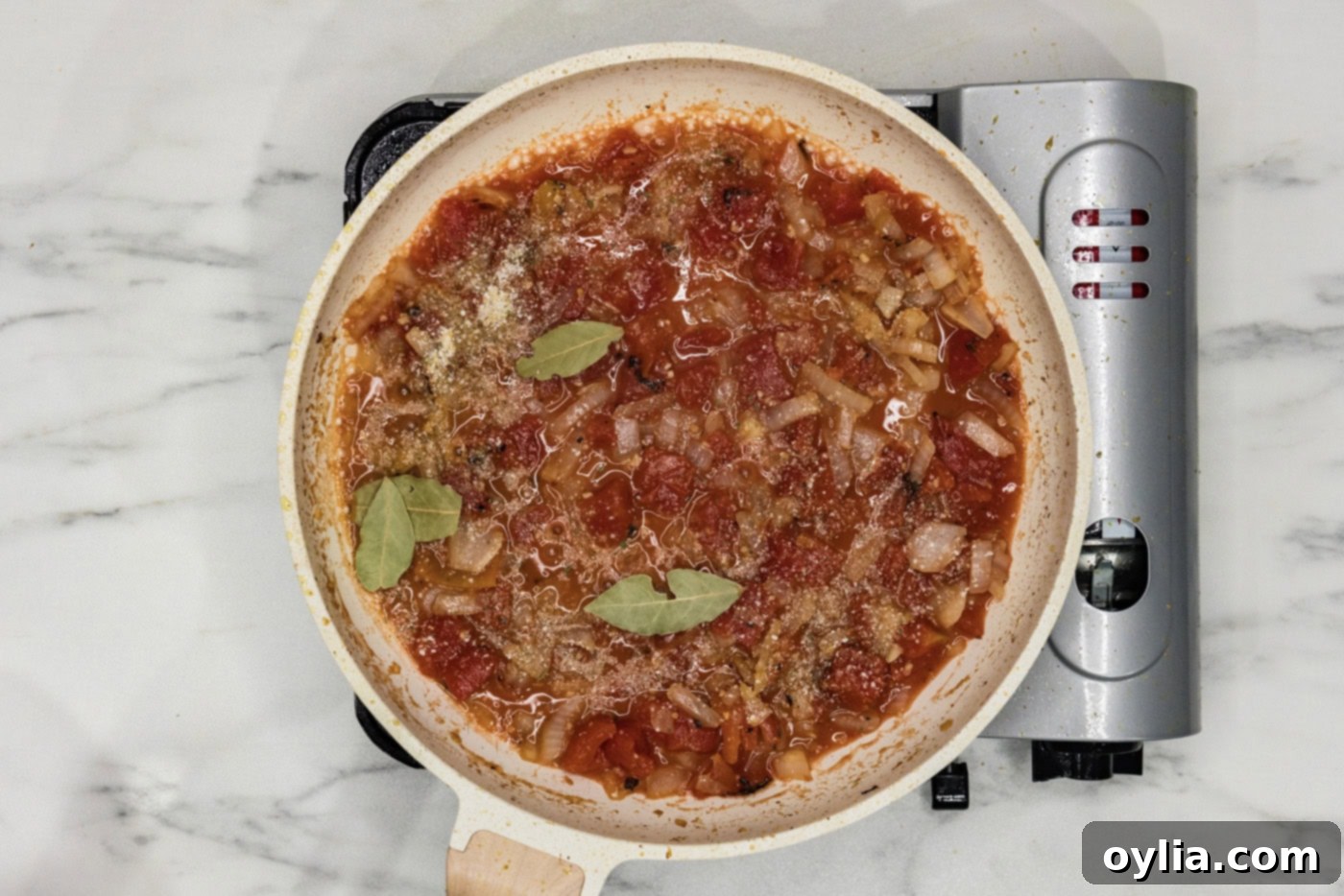 tomatoes, wine, and bay leaves added to skillet