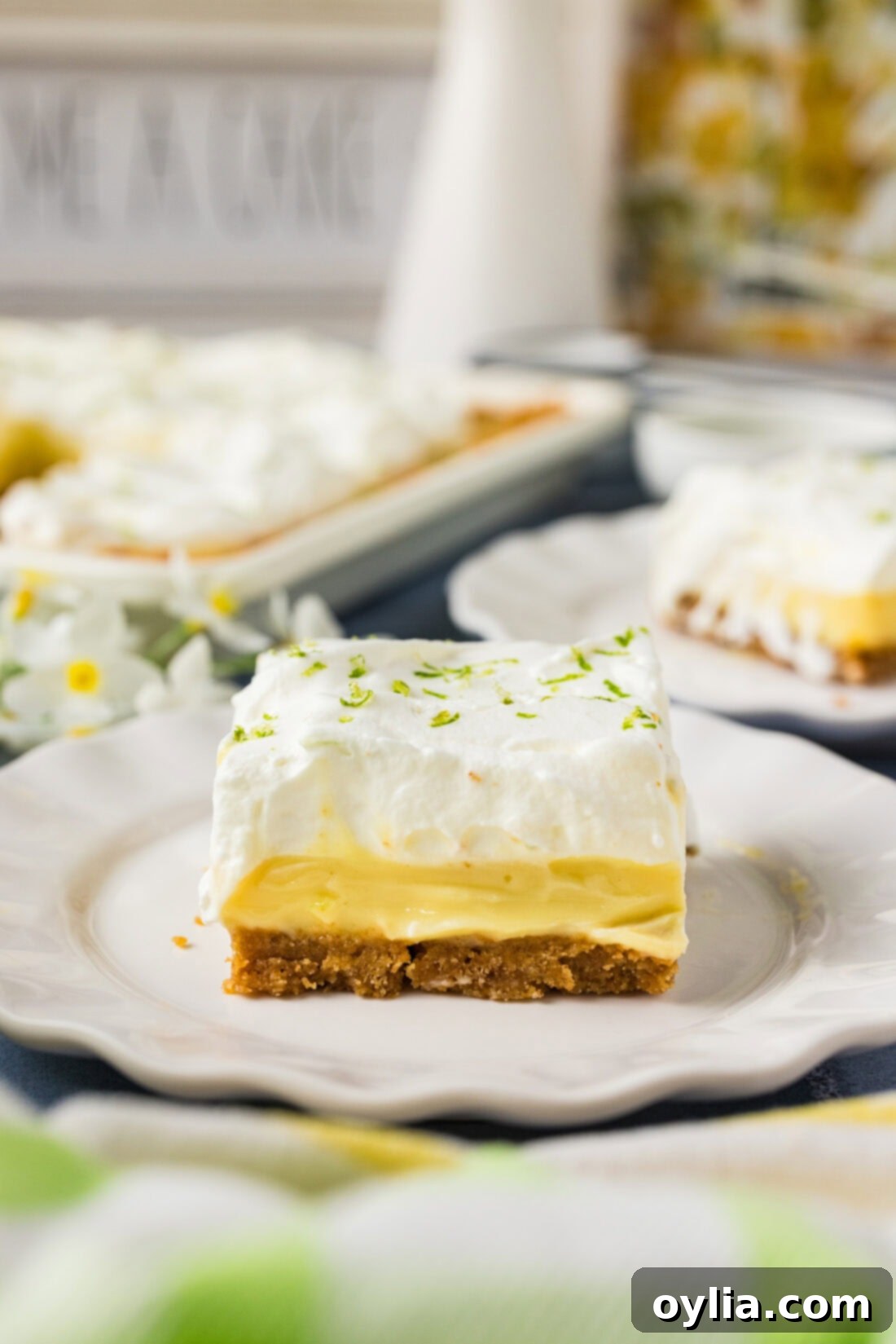 A perfectly portioned slice of Key Lime Slab Pie on a white plate, showcasing its layers