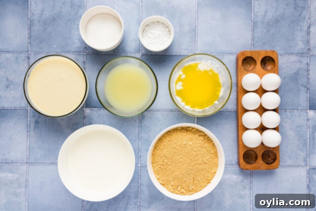 All the fresh ingredients laid out for making Key Lime Slab Pie, including limes, eggs, butter, and graham crackers