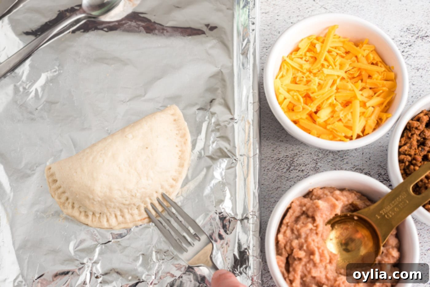 sealing empanadas with a fork