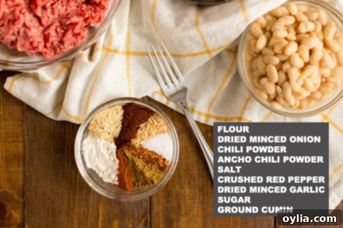 Close-up of a bowl containing homemade chili seasoning ingredients, including various spices and dried minced onion.