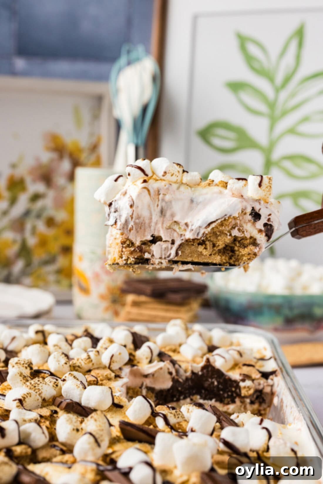 Ultimate S'mores Lasagna 3 Slice of S'mores Lasagna being lifted out of the pan, showing the distinct layers