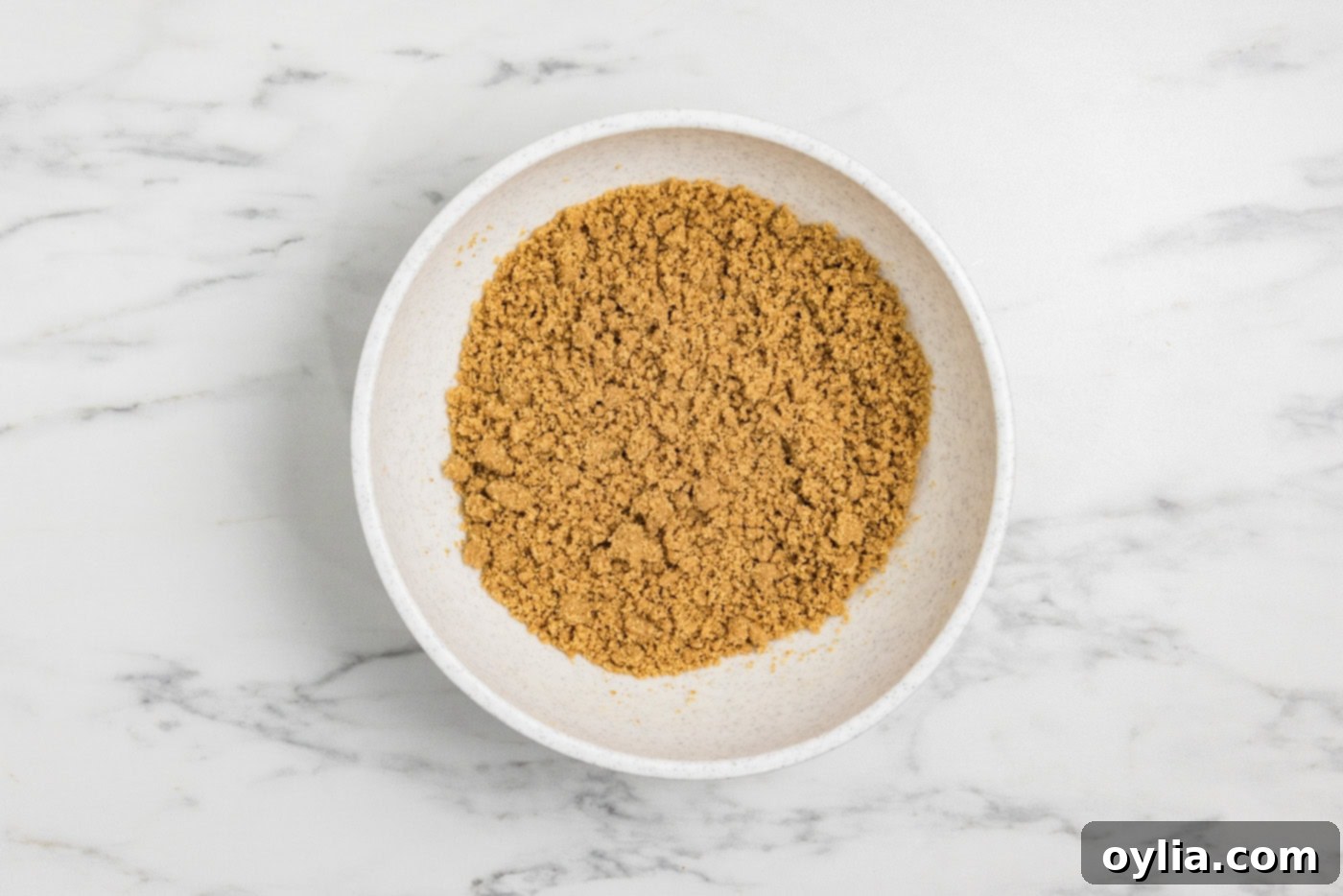graham cracker crumbs mixed with melted butter in a bowl