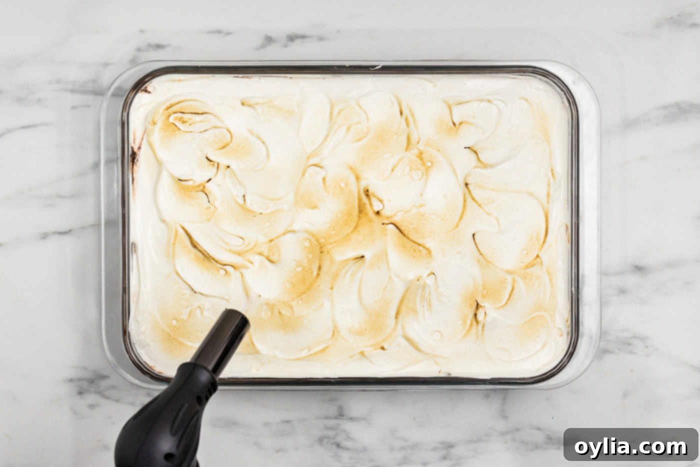 kitchen torch lightly browning marshmallow topping on the s'mores lasagna