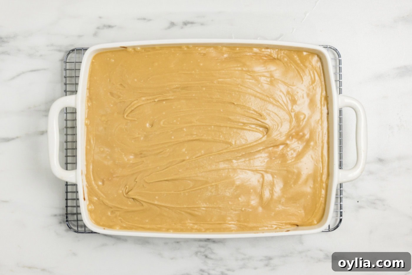 caramel icing spread over peach cake in a dish