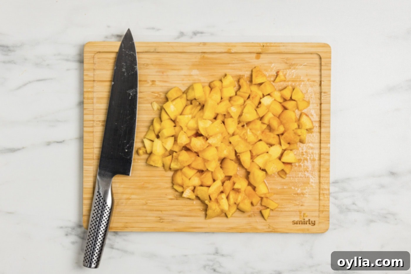 chopped peaches on a cutting board with a knife