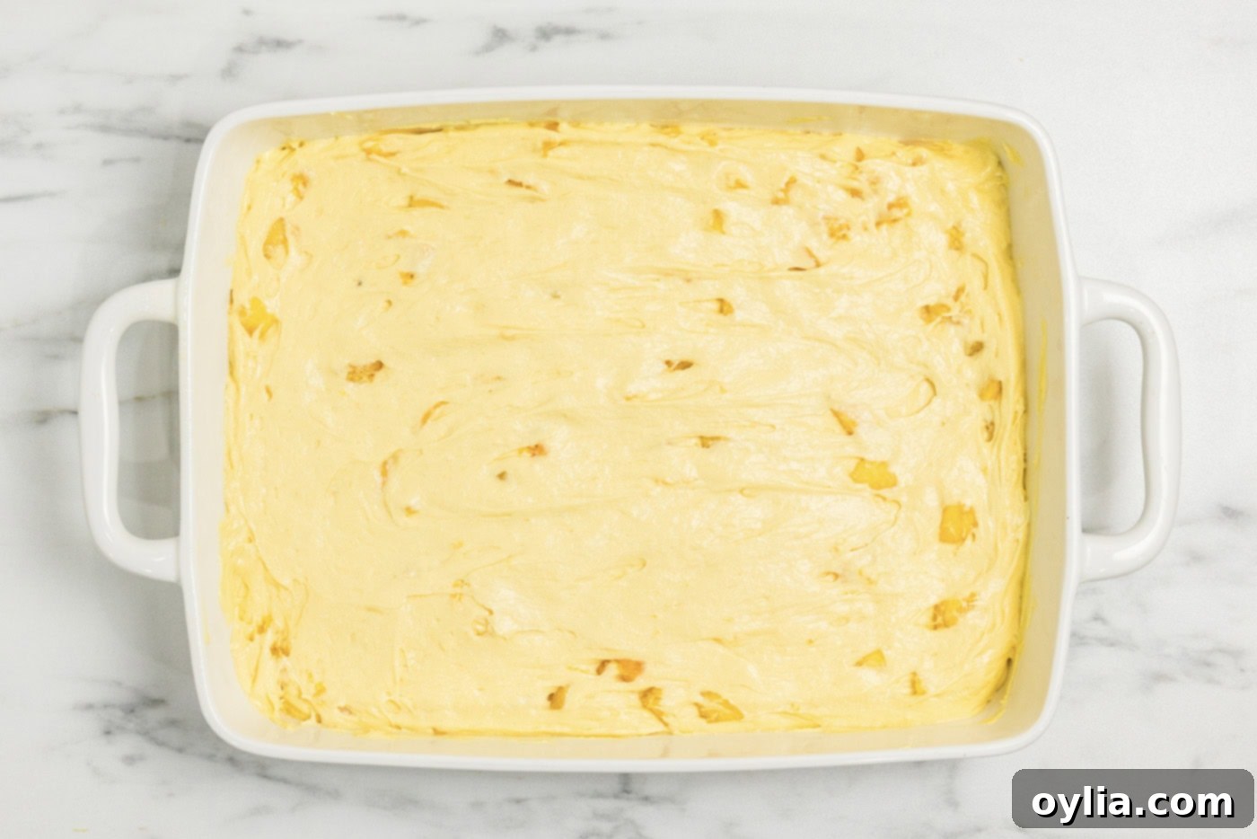 peach cake batter in a baking dish