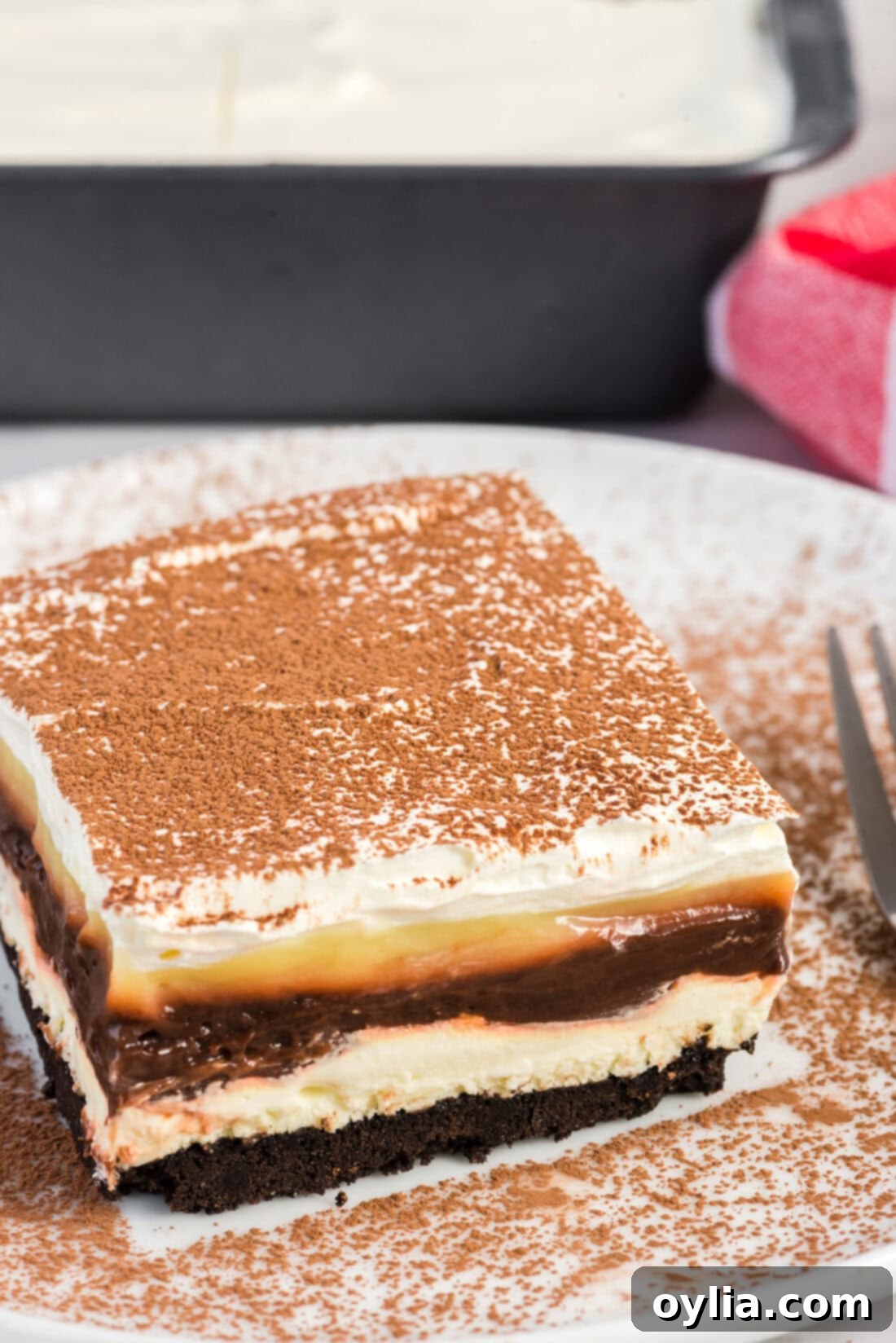 A pristine, perfectly cut slice of Sex in a Pan dessert resting on a simple white plate, ready to be enjoyed.