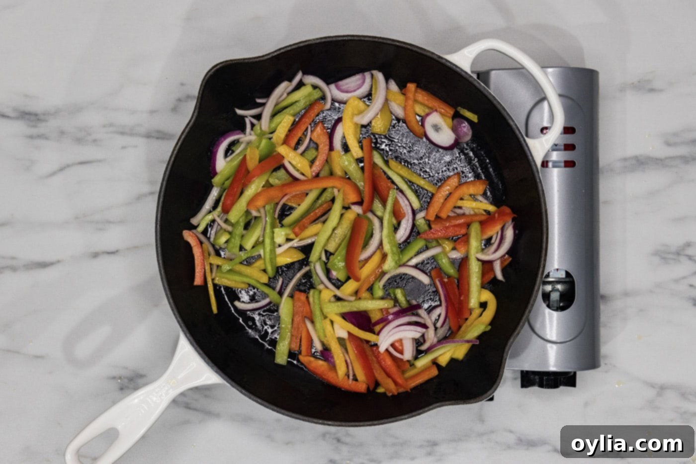 sauteeing bell peppers and onions in a skillet