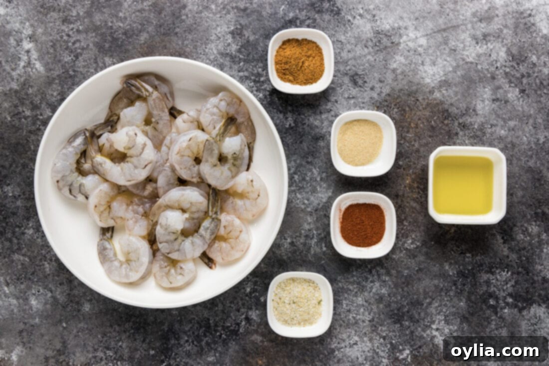 All the ingredients laid out for broiled shrimp: raw shrimp, olive oil, and various spices in small bowls