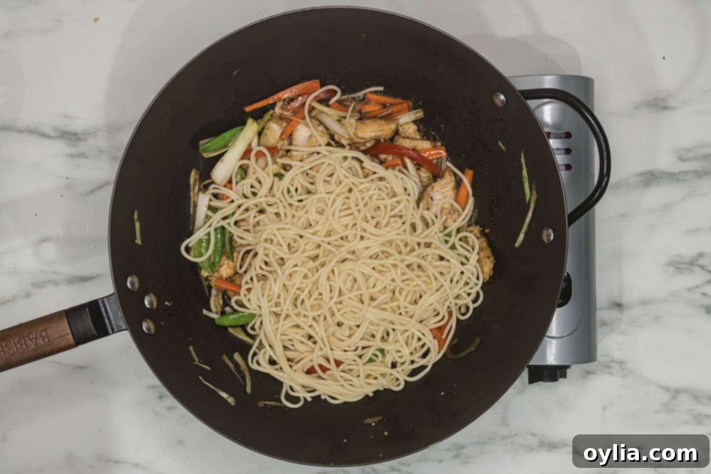 lo mein noodles added to skillet with vegetables and chicken