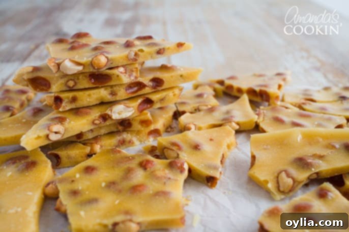 Broken pieces of homemade peanut brittle on a baking sheet