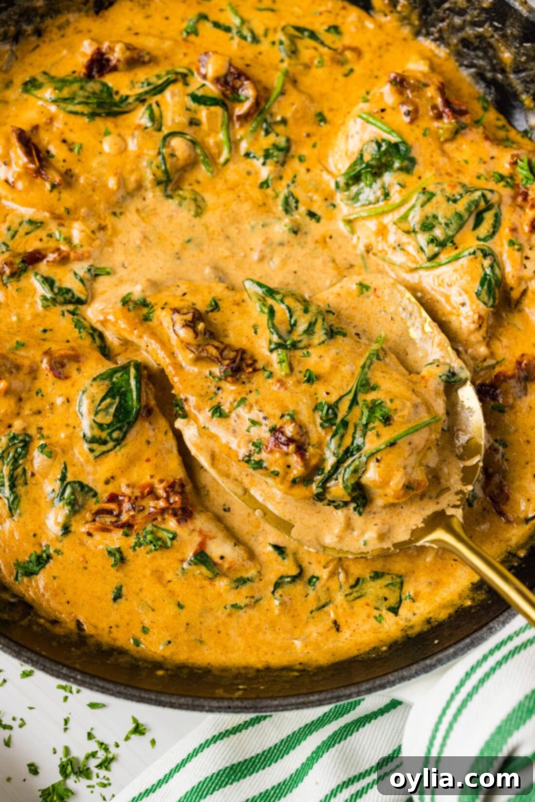 Creamy Tuscan Chicken 3 Close up photo of a spatula in a skillet of Tuscan Chicken