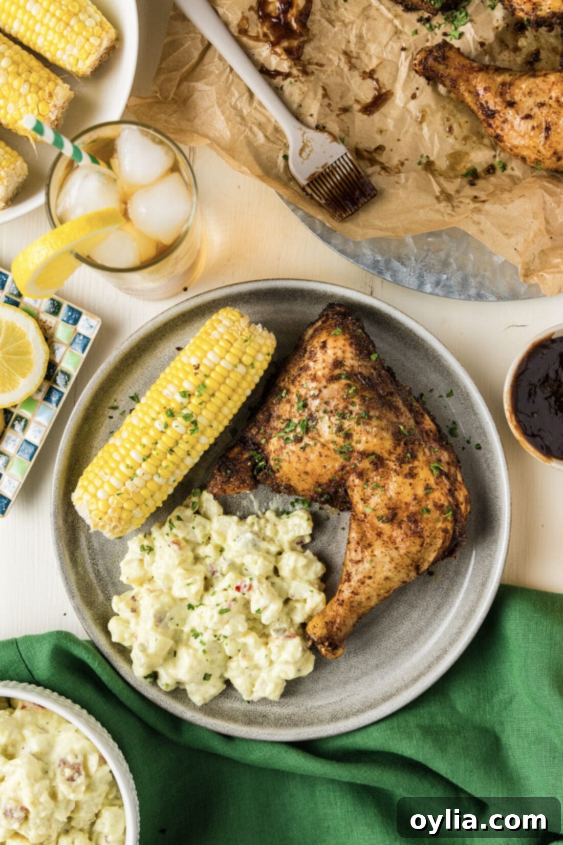 Perfectly Smoked Chicken Quarters 7 Smoked Chicken Quarter on a plate with potato salad and corn on the cob, ready to be enjoyed.