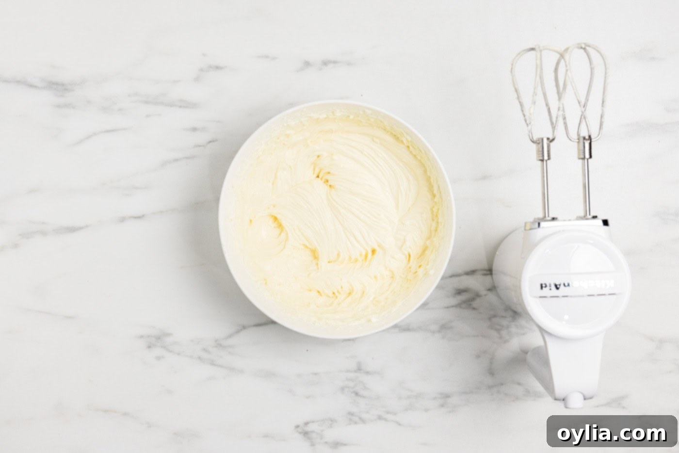 cheesecake batter in a bowl next to an electric mixer