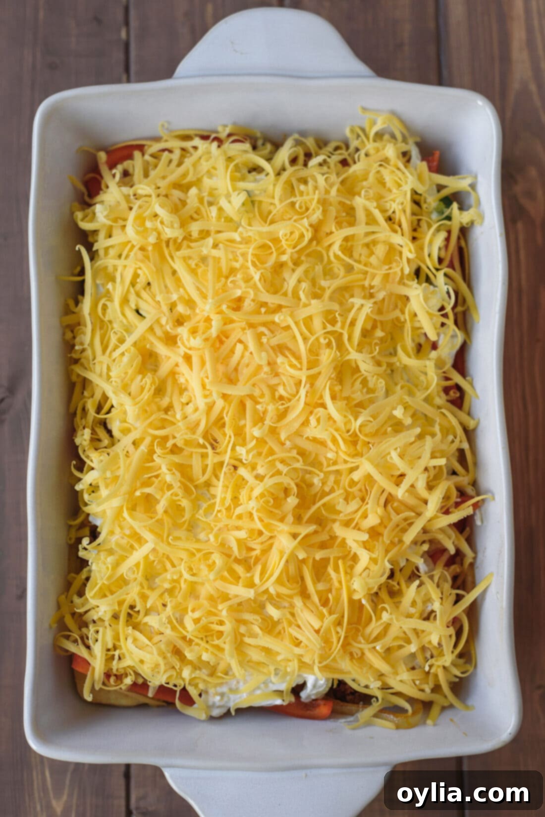 The assembled John Wayne Casserole, topped with a generous layer of shredded cheese, before its final bake.