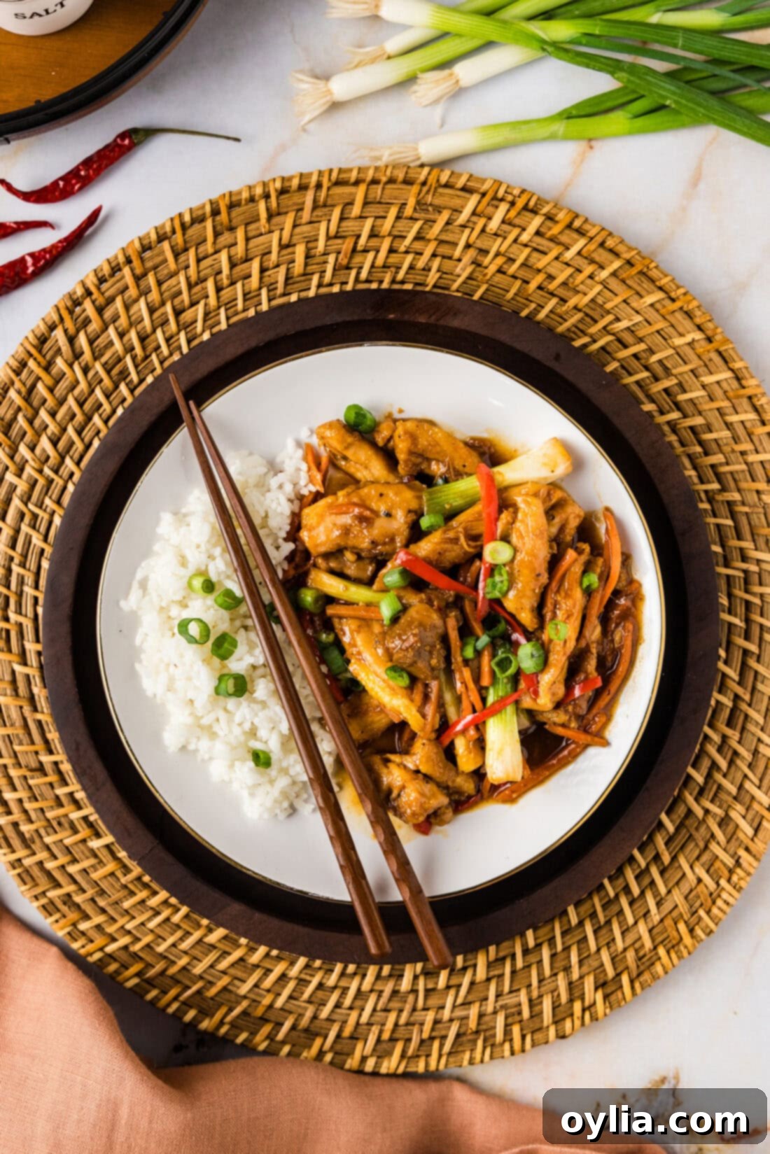 Spicy Szechuan Chicken 2 Plate of Szechuan Chicken with rice and chopsticks, showcasing the rich sauce and vibrant vegetables.