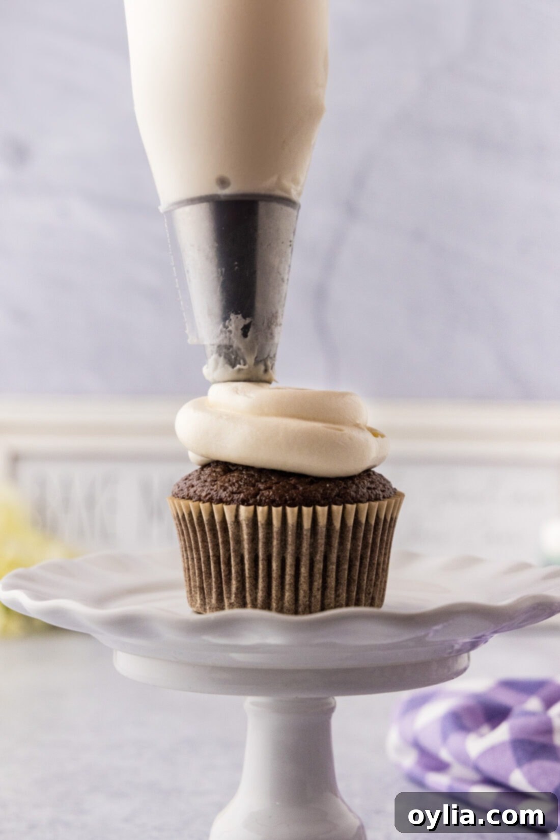 Marshmallow Frosting being piped on a cupcake