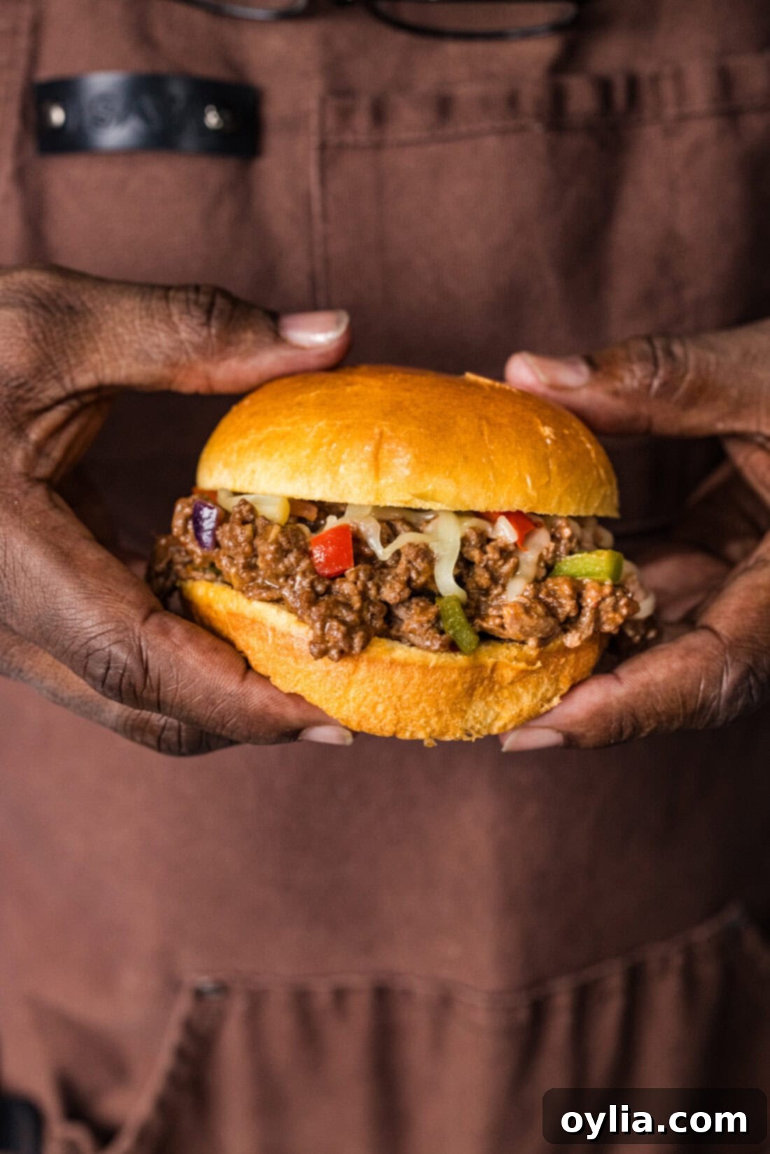 Hands holding a Philly Cheesesteak Sloppy Joe