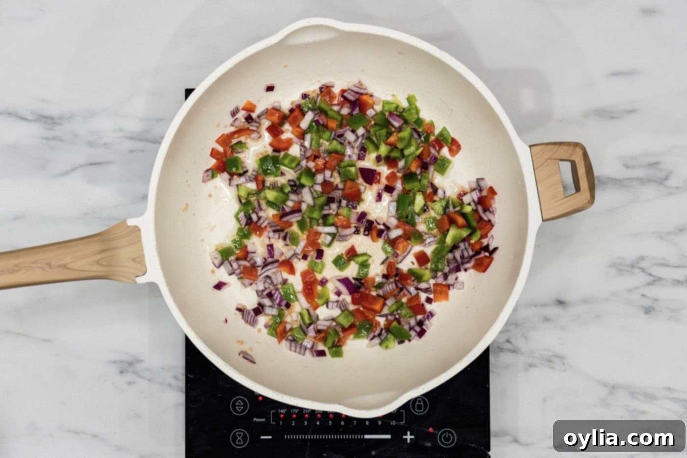 bell peppers, onion, and garlic sauteeing in a skillet