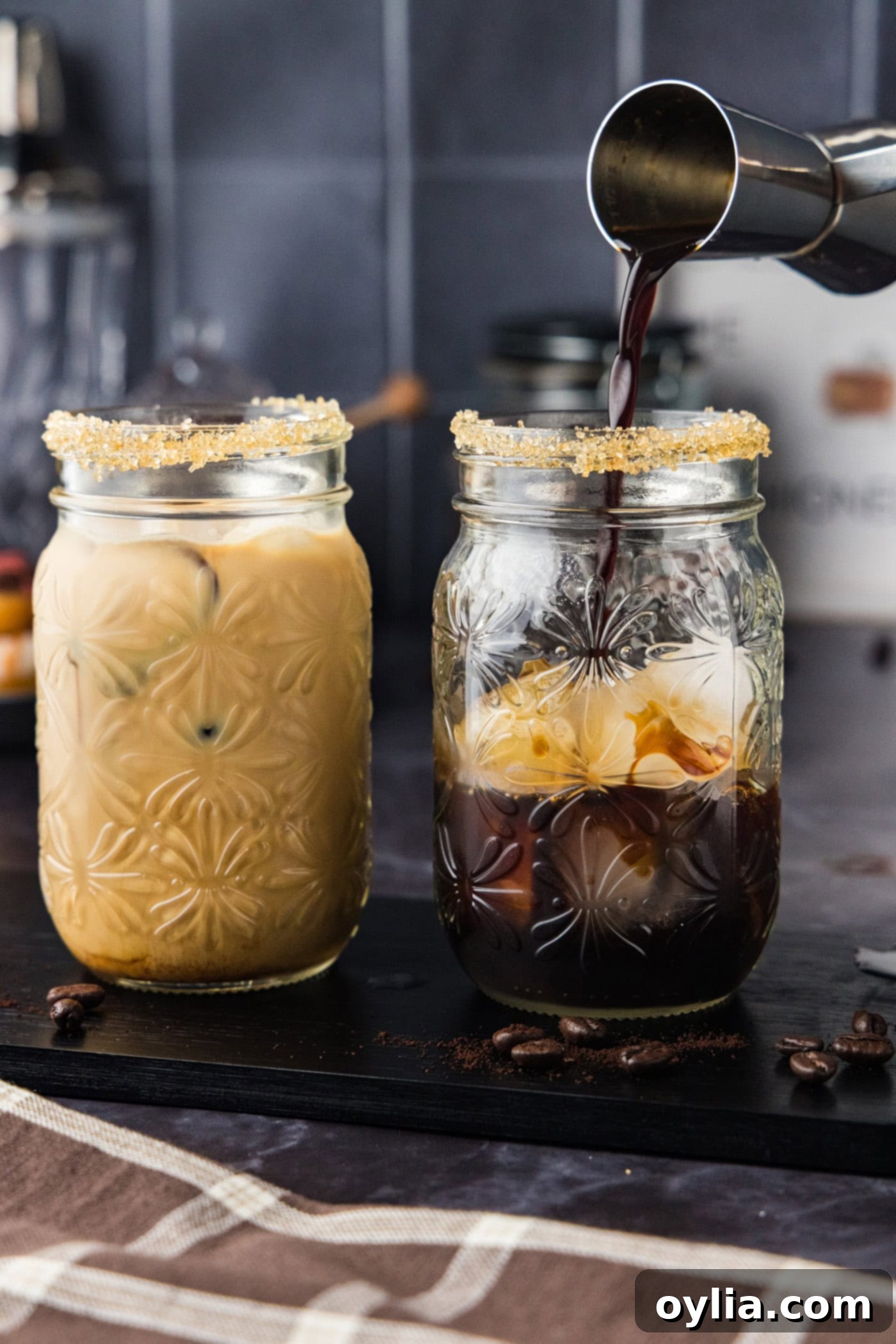 jigger pouring espresso into glass with vodka