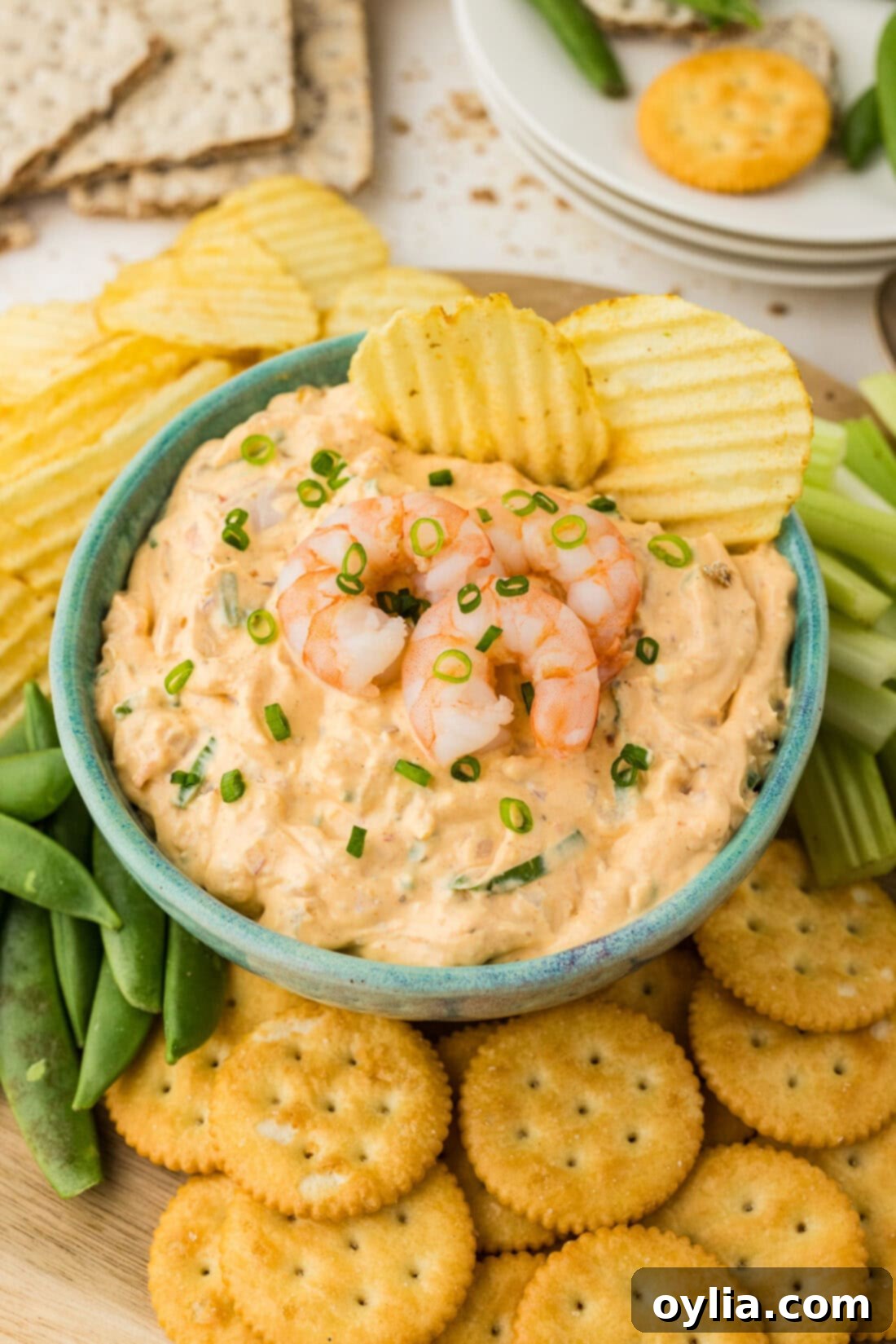 Close up photo of a bowl of Shrimp Dip with two chips in it, highlighting its creamy texture and visible shrimp pieces