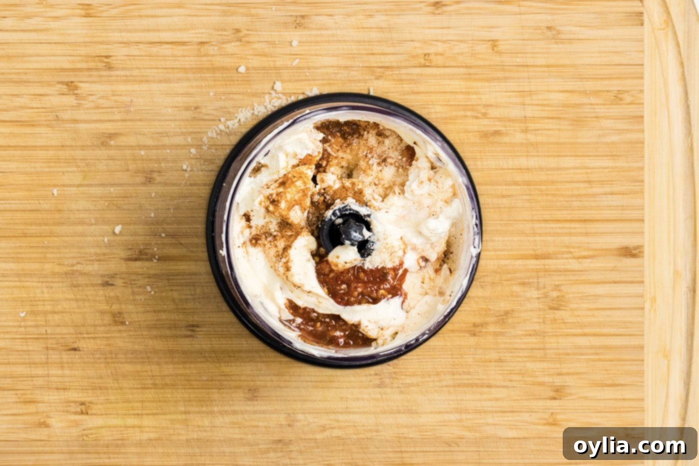 overhead photo of all the sauce ingredients, including cream cheese, mayo, and spices, in a mini food chopper bowl