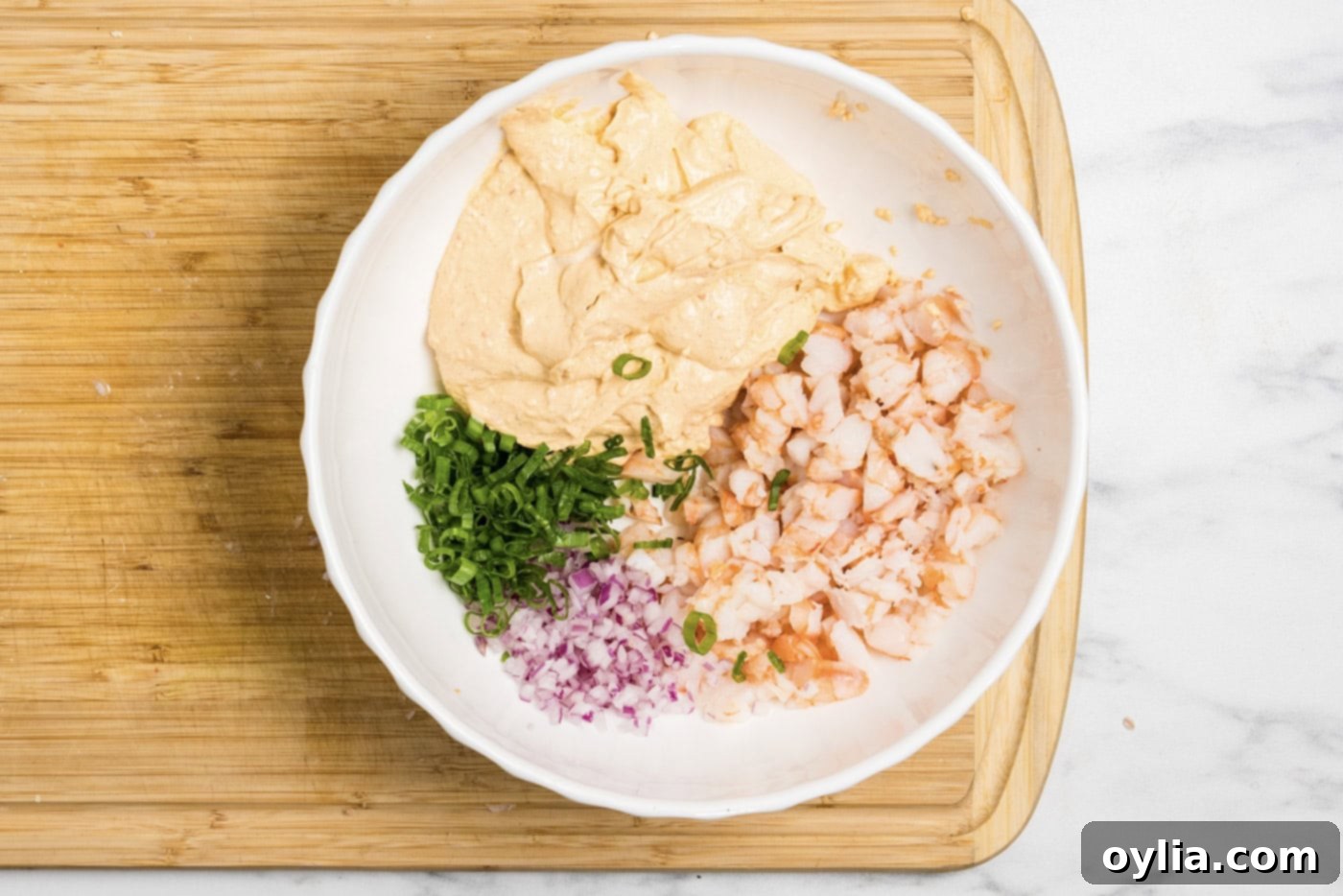 Photo of all shrimp dip ingredients mixed together in a large bowl, showing its ready-to-chill state