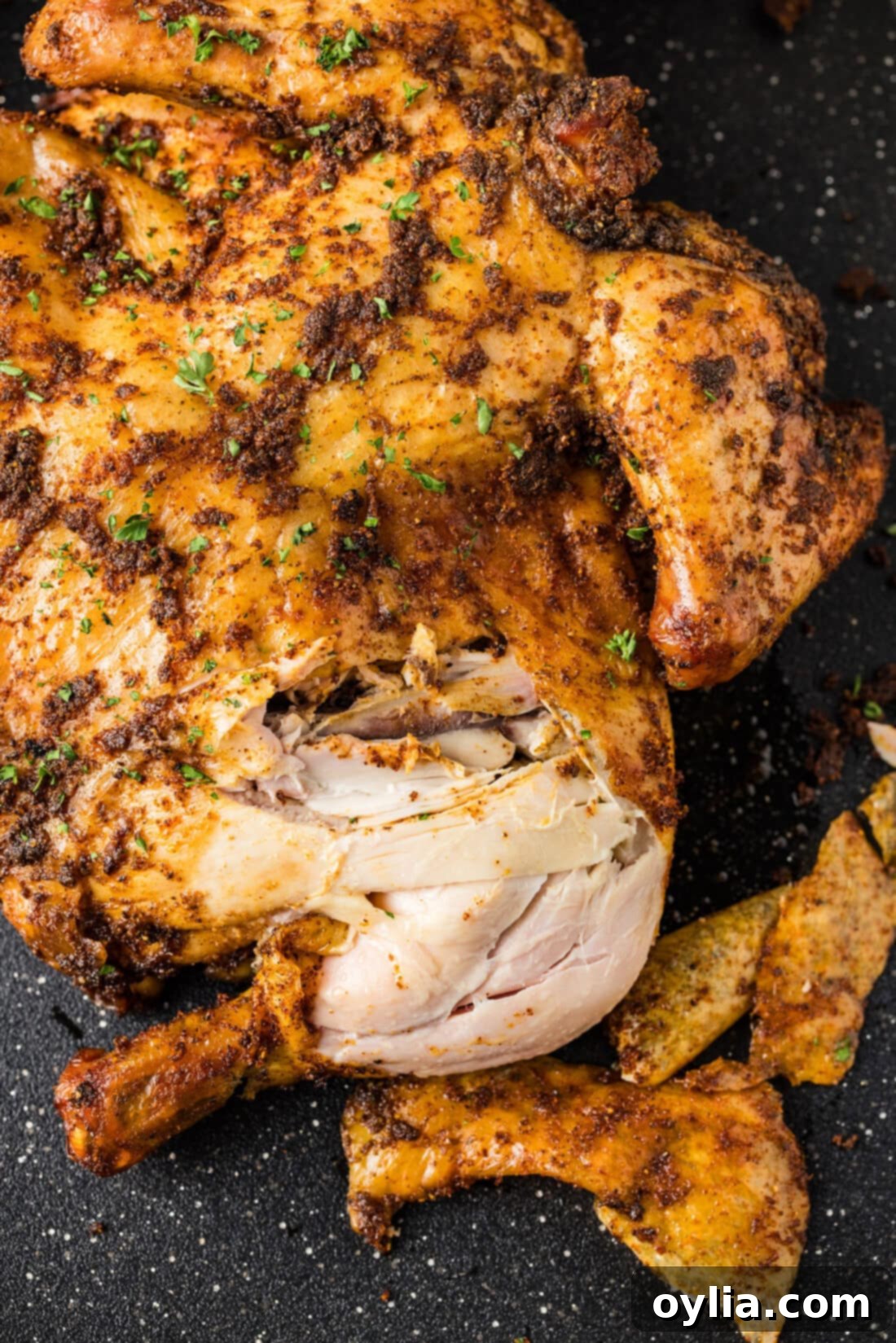 Close up photo of a Smoked Spatchcock Chicken, carved into pieces, showing its juicy interior.