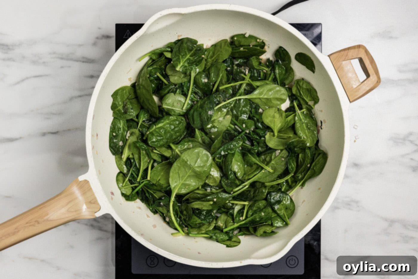 spinach leaves added to skillet with butter, garlic, and shallots