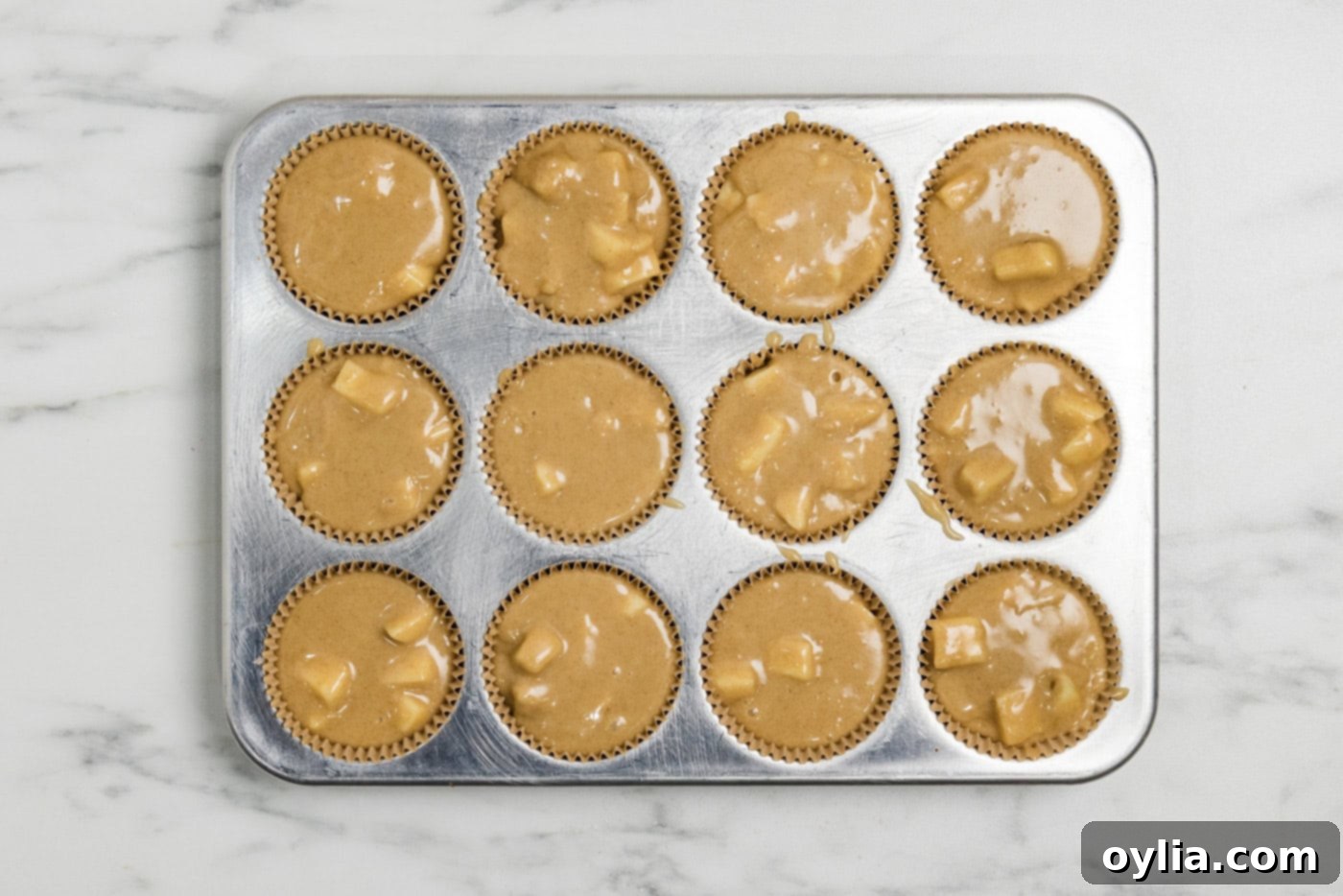 apple muffin batter in a muffin tin