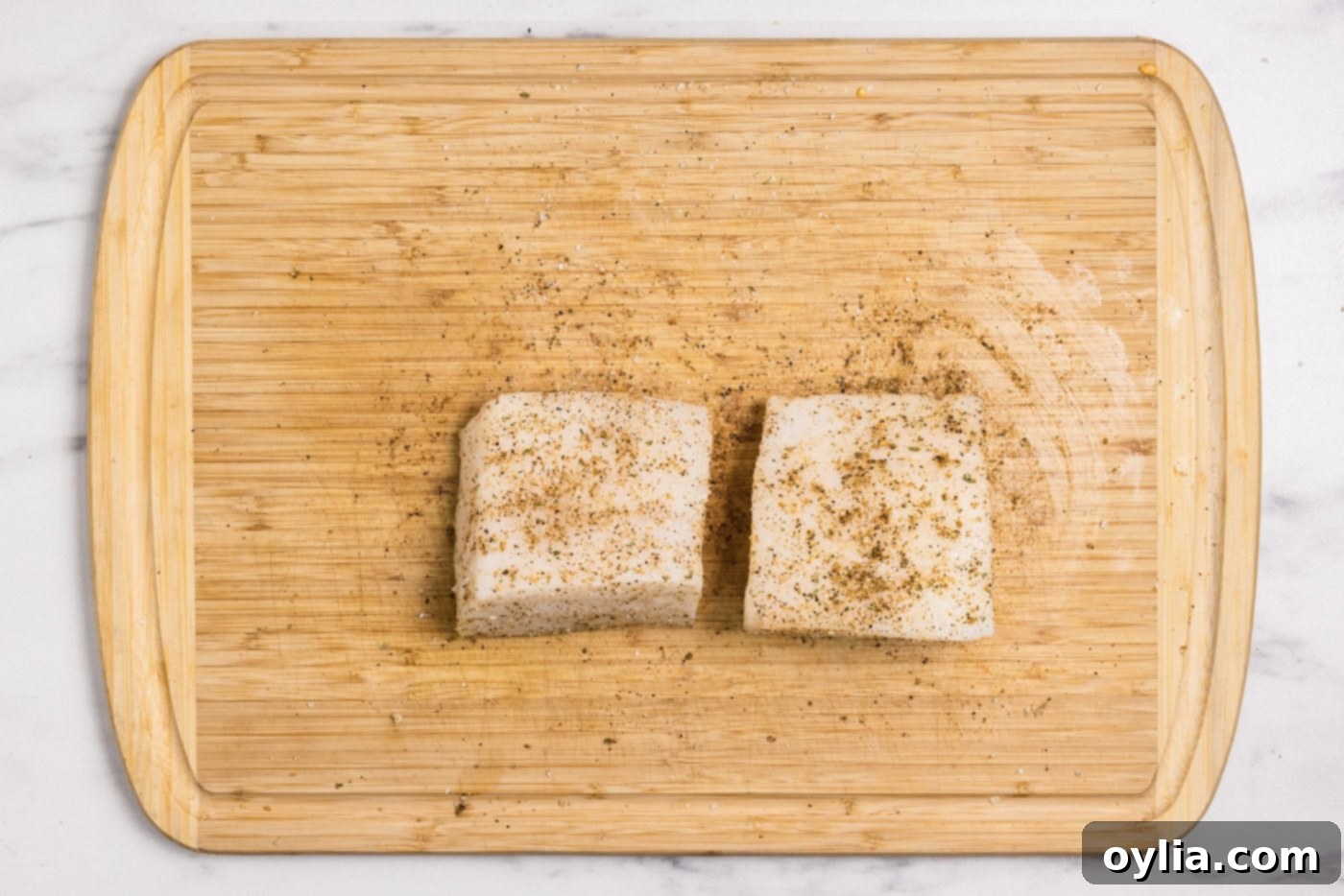 seasoned chilean sea bass filets on a cutting board