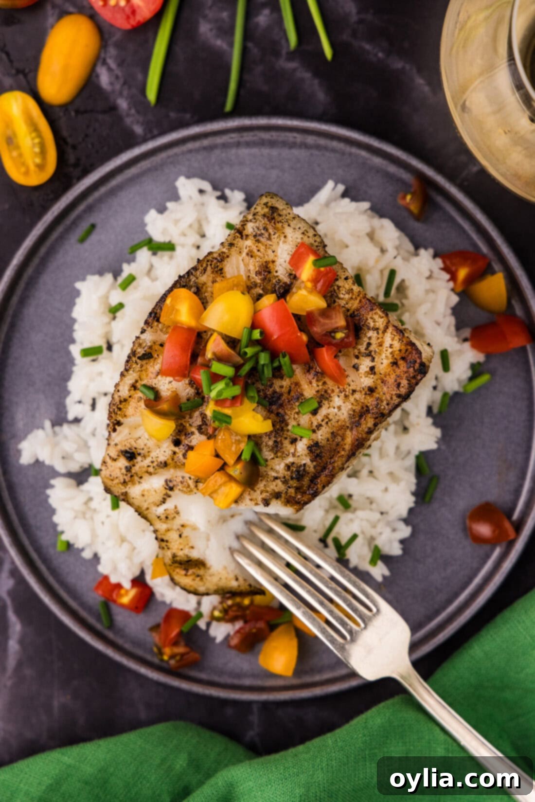 Overhead photo of Grilled Chilean Sea Bass resting over white rice on a plate
