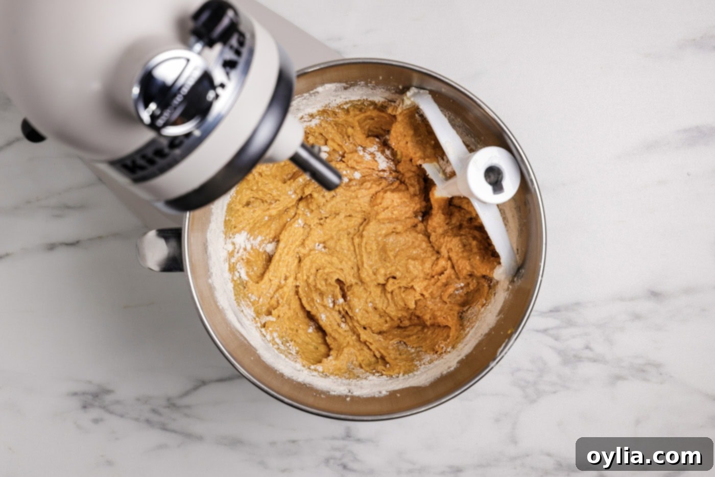 Pumpkin muffin batter in a stand mixer bowl, showing the consistency before adding mix-ins.