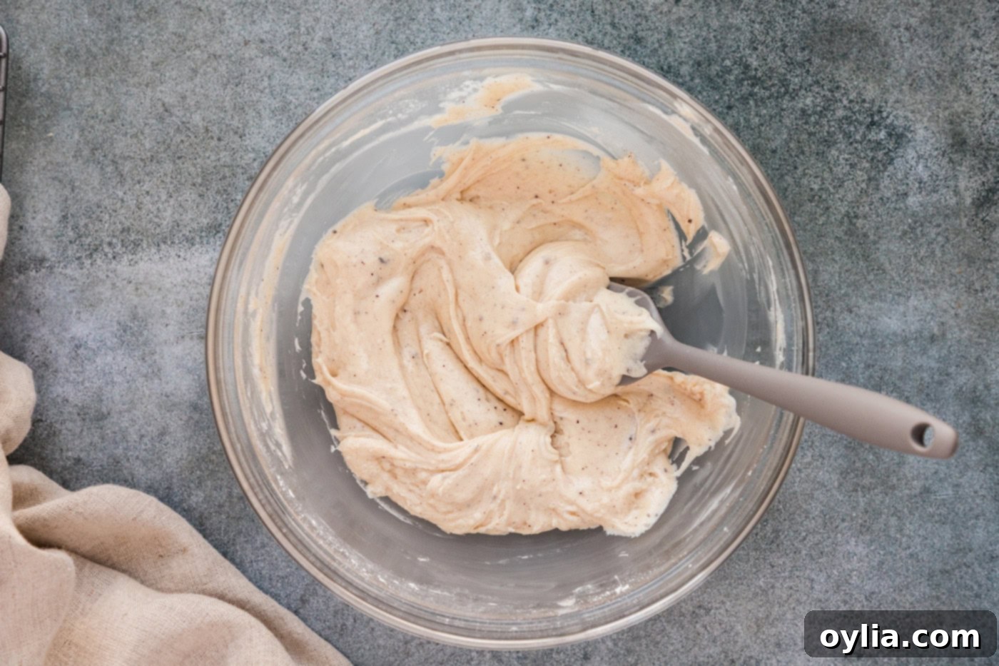 brown butter glaze in a mixing bowl with a rubber spatula