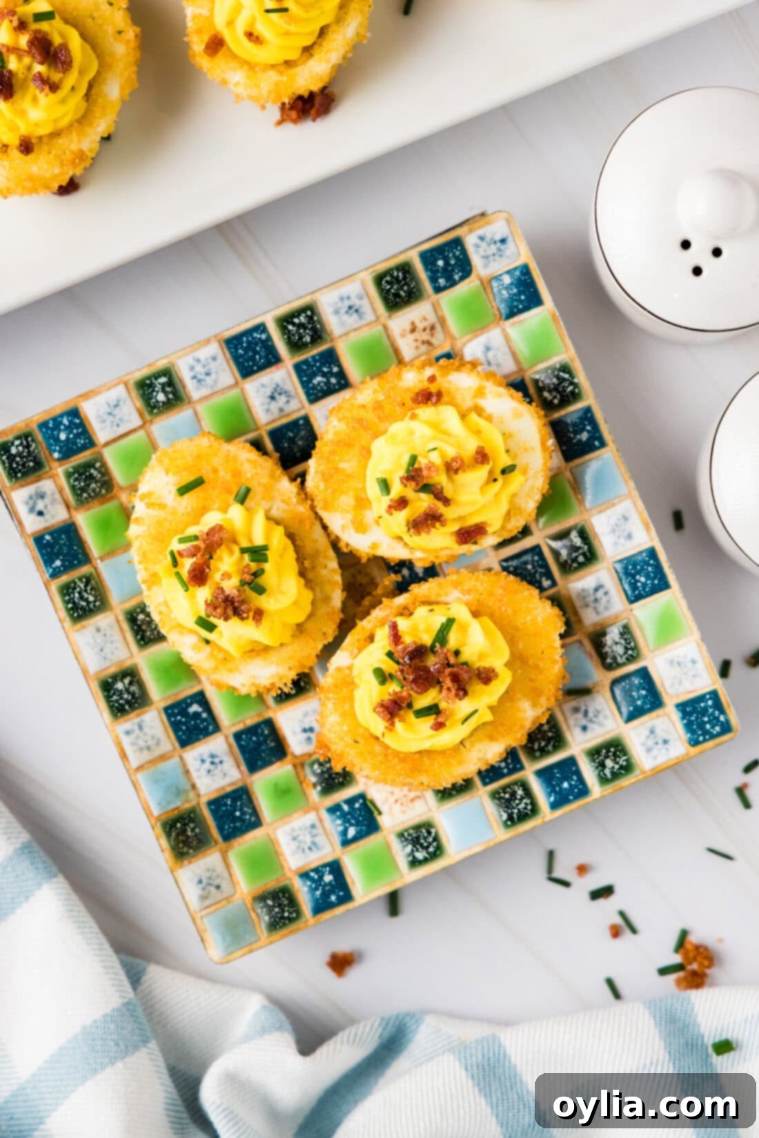Three Fried Deviled Eggs on a square plate