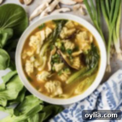 Bowl of Wonton Soup with green onions, mushrooms and baby bok choy around it