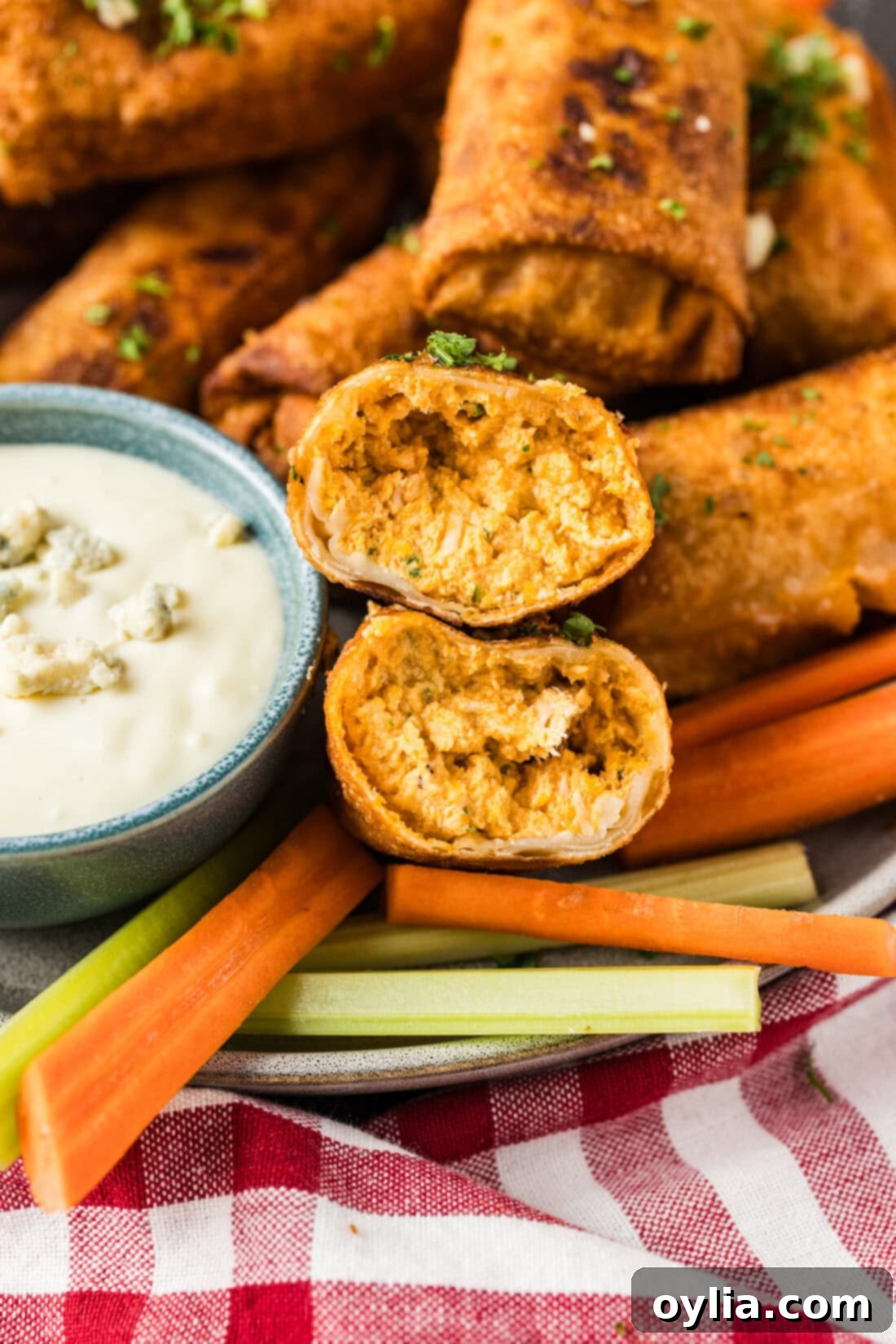 Close up photo of a Buffalo Chicken Egg Roll cut in half, revealing the creamy, cheesy, and spicy chicken filling
