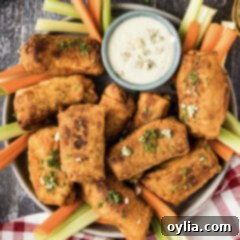Platter of Buffalo Chicken Egg Rolls with carrots, celery and a bowl of blue cheese dressing