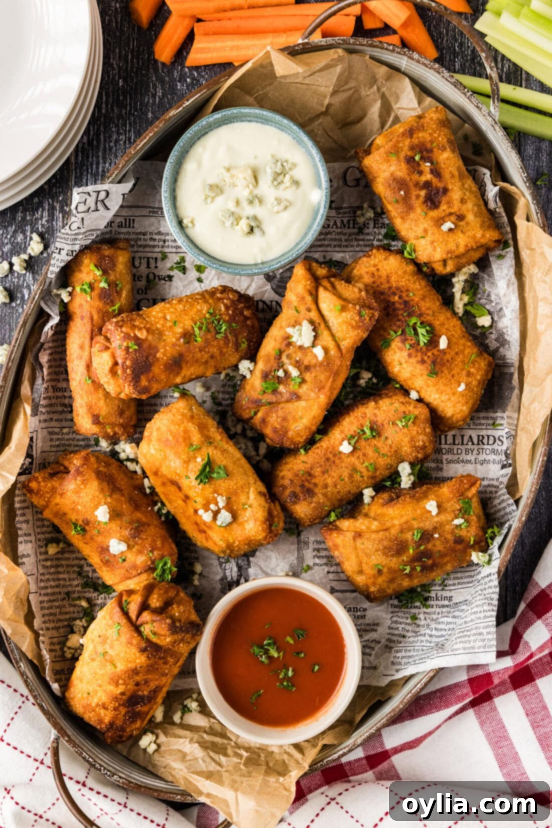 Platter of Buffalo Chicken Egg Rolls with bowls of blue cheese dressing and buffalo sauce, perfect for dipping