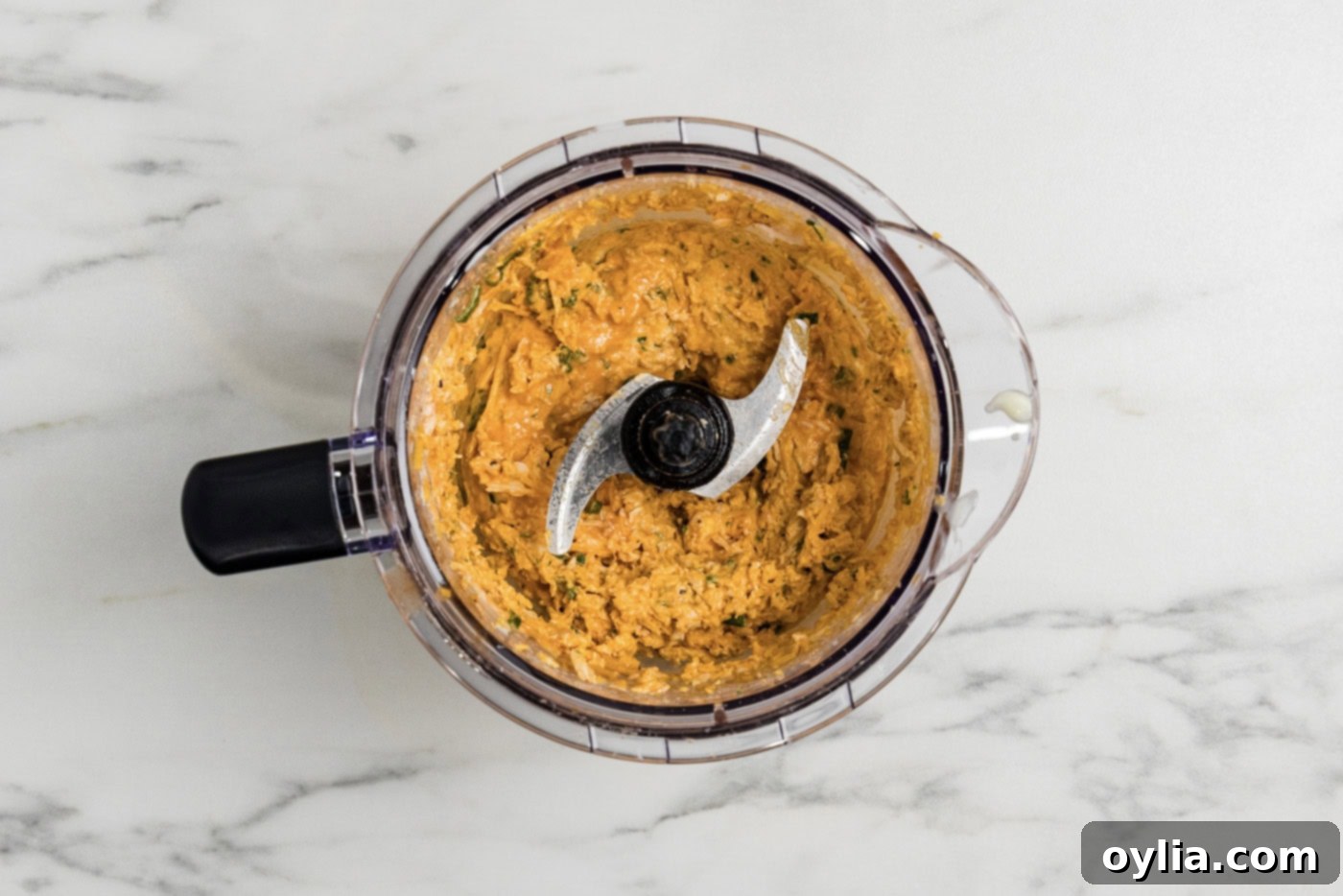 Close-up of buffalo chicken mixture being blended in a food chopper