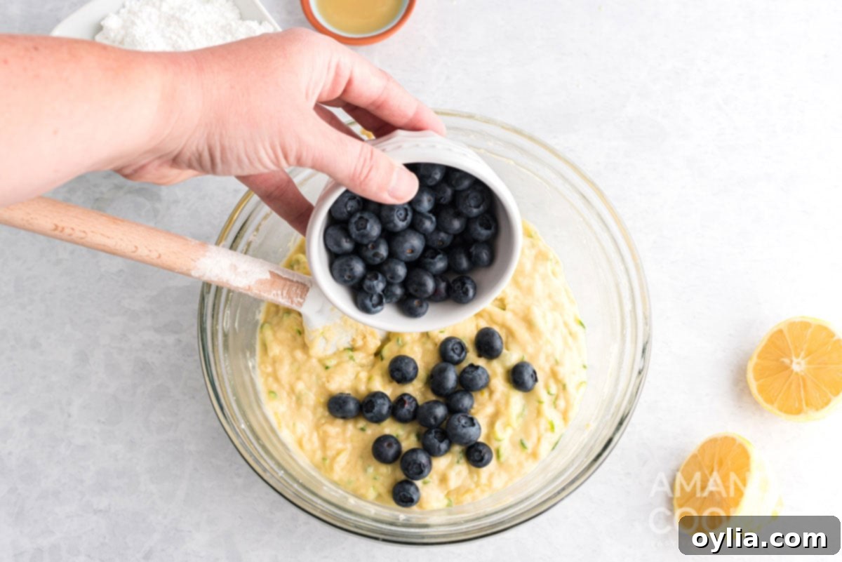 Blueberries being gently folded into the zucchini bread batter