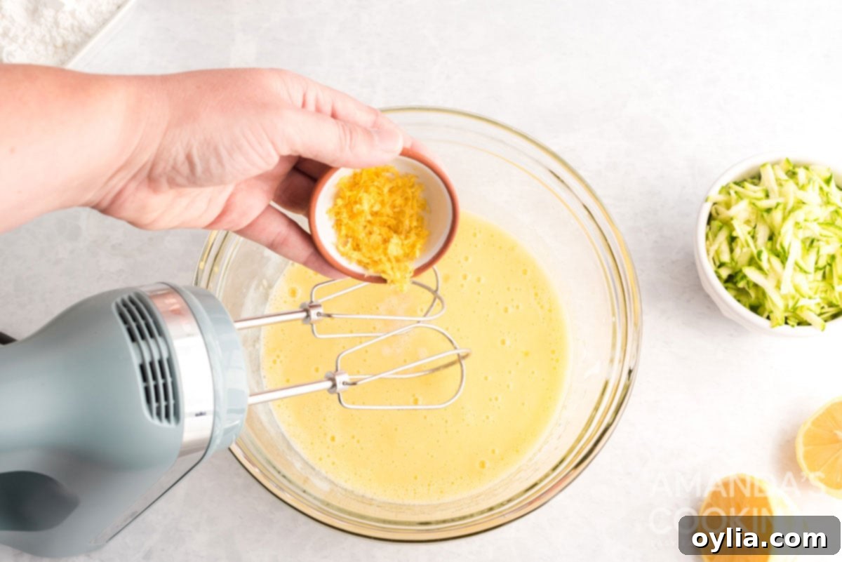 Fresh lemon zest being added to the wet ingredients for lemon blueberry zucchini bread.