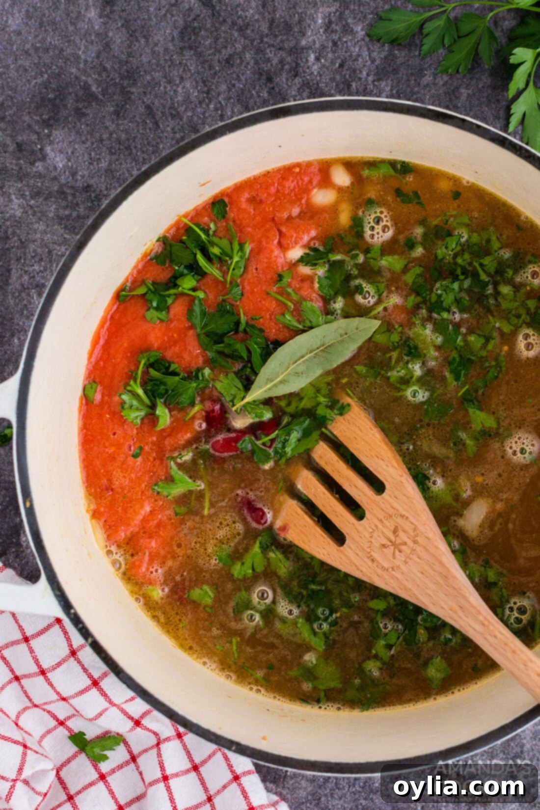 Stirring vegetables and broth in a large Dutch oven for chicken bean soup